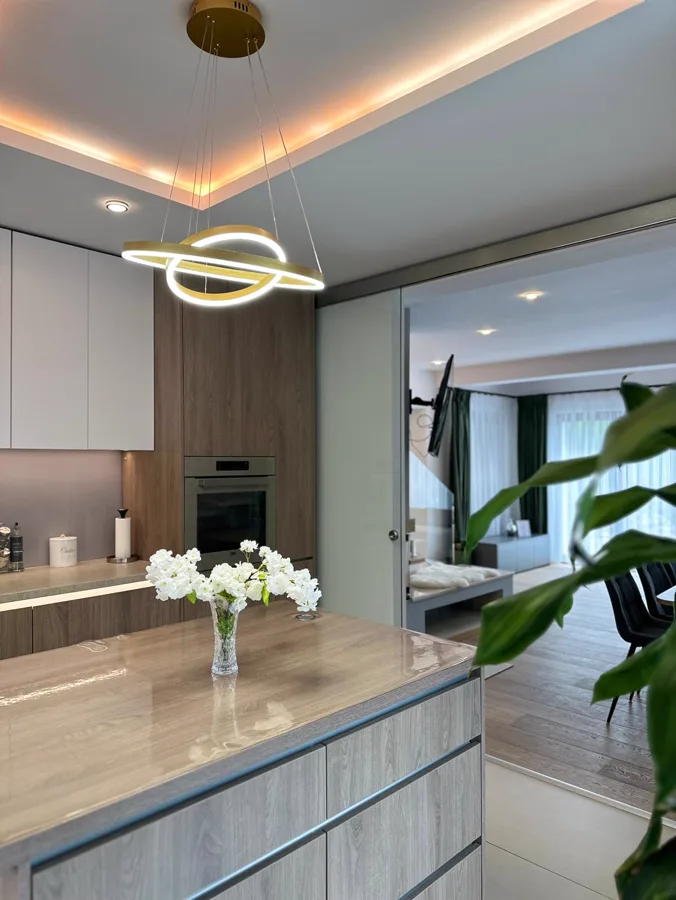 Modern kitchen with island, pendant light and view towards the living room